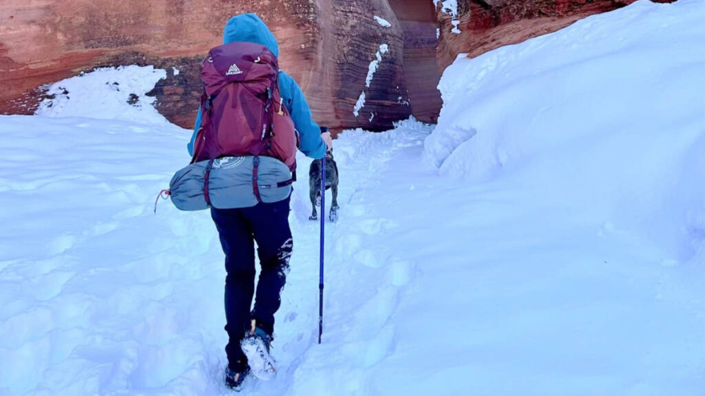 A woman using a Gregory Maven backpack with her dog