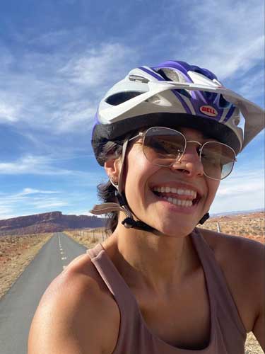 The author smiling for a photo while biking in Moab