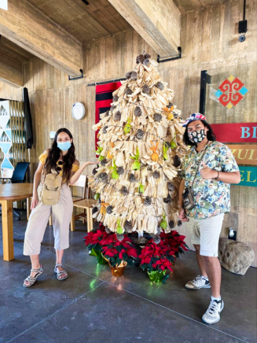 The author McKenna Mobley with a man, posing near the Christmas tree of tamales