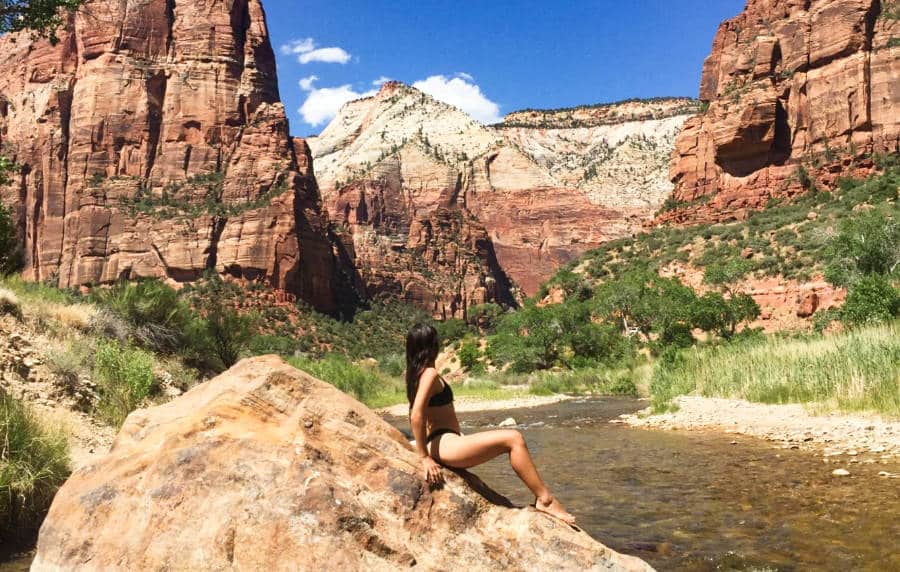 The author McKenna Mobley posing on a rock after a swim in Zion National Park
