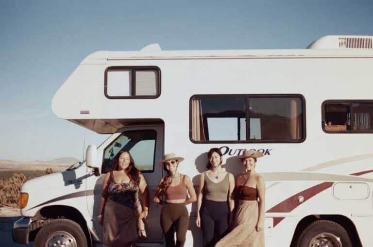 McKenna and her friends with the motorhome on their background in Moab