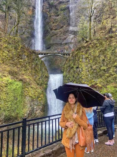 McKenna holding an umbrella at the Multnomah Falls