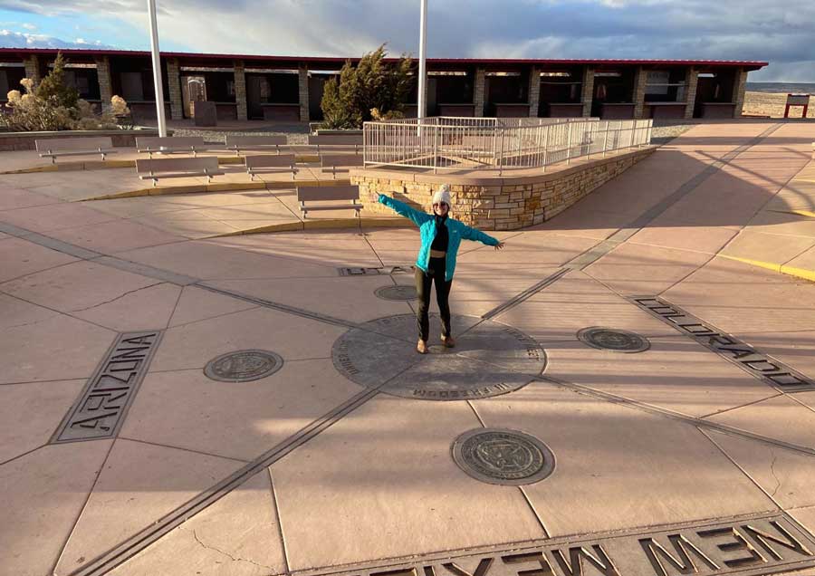 Travel Lemming writer McKenna posing for a photo at the Four Corners Monument