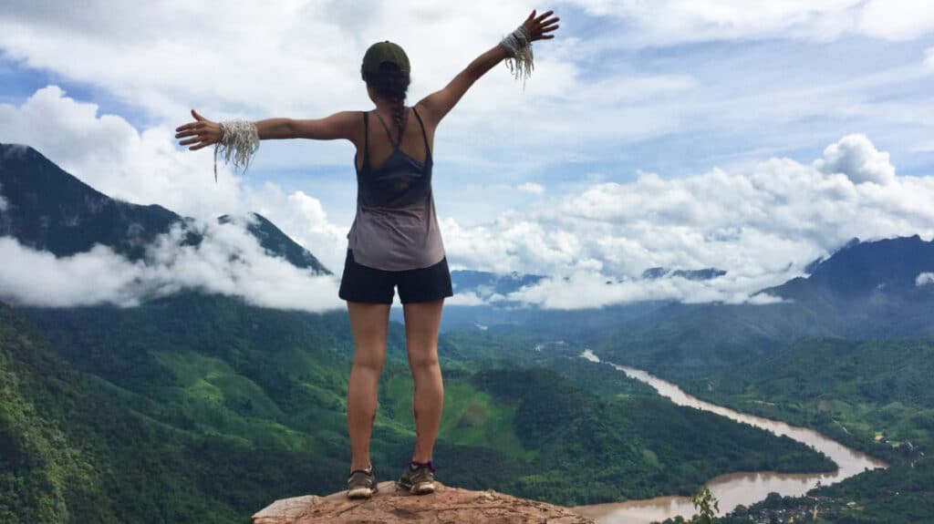 The author McKenna Mobley, standing on a cliff while admiring the magnificent view from the trail