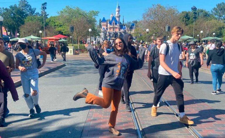 The author McKenna Mobley posing for a photo near the trolley tracks on Main Street in Disneyland