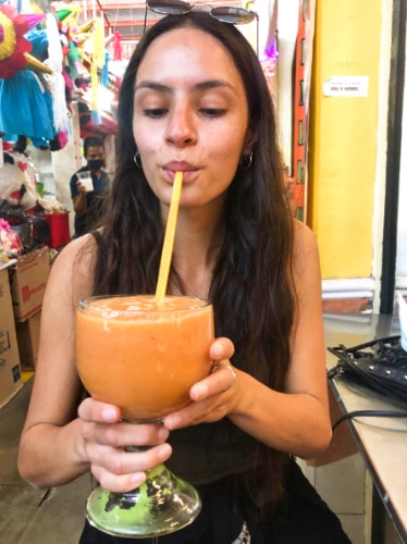 The author McKenna Mobley, drinking on a huge glass at the local market