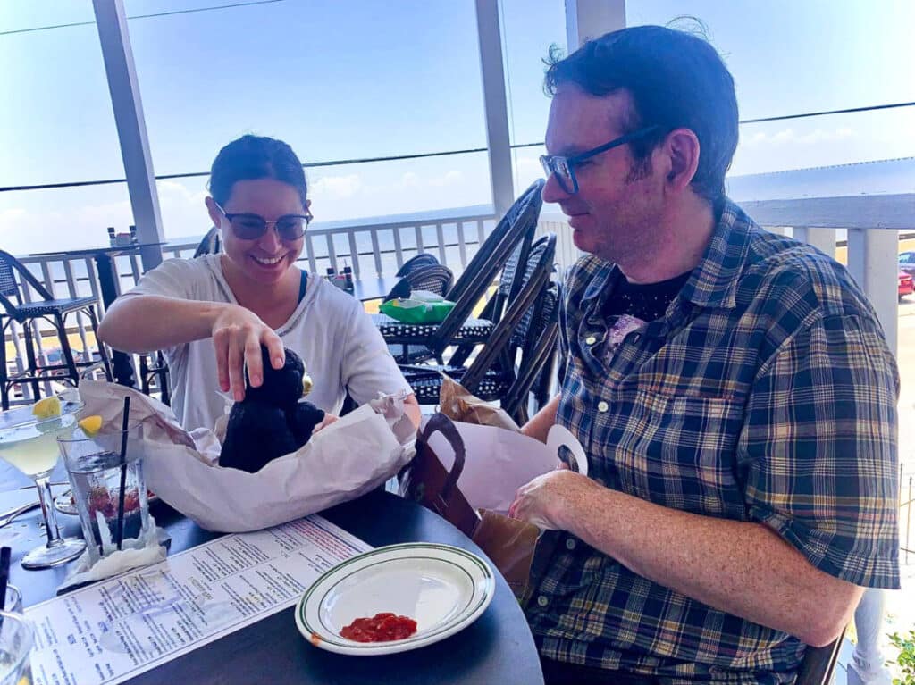 The author Meg O'Connor and her partner, Casey, opening a present at Rips on the Lake on the Mandeville Lakefront