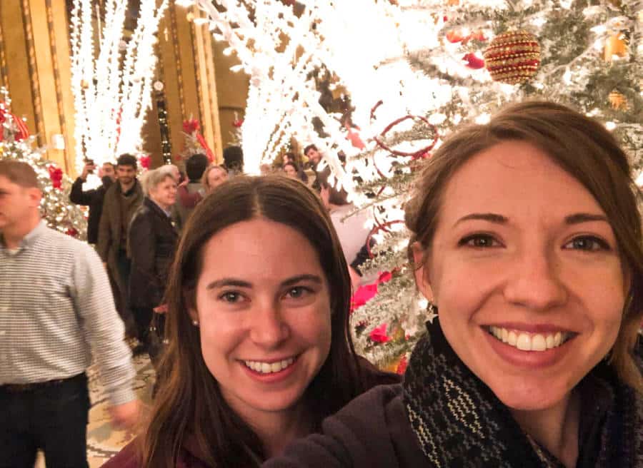 The author Meg and her friend posing near the Christmas decorations in Roosevelt Hotel