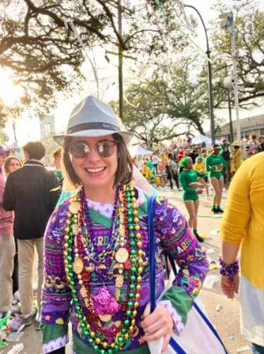 The author Meg O'Connor with colorful beads around her neck at the Mardi Gras Parade