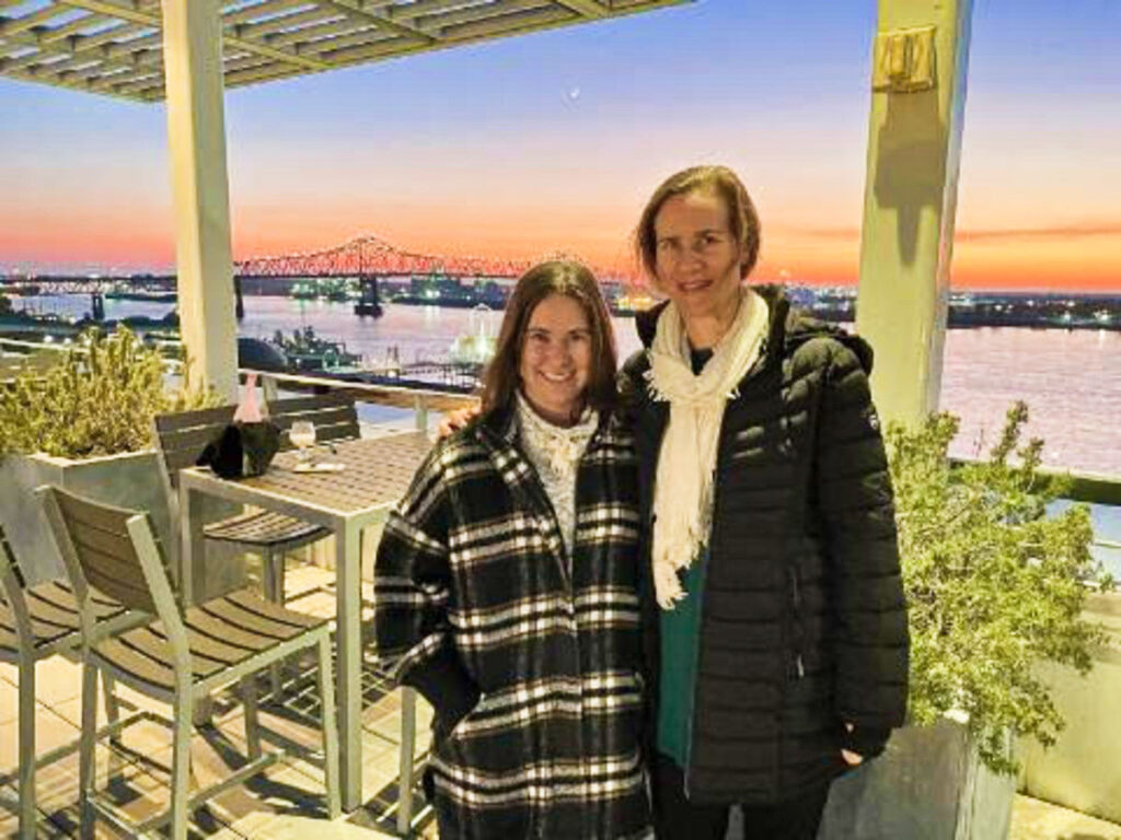 The author Meg O'Connor and a woman smiling for a photo at the rooftop restaurant Tsunami in the Shaw Center