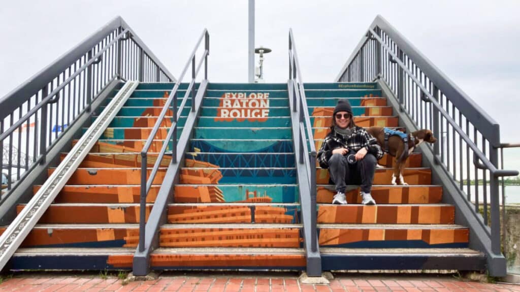 The author Meg and her dog posing at the steps leading to the Mississippi River levee