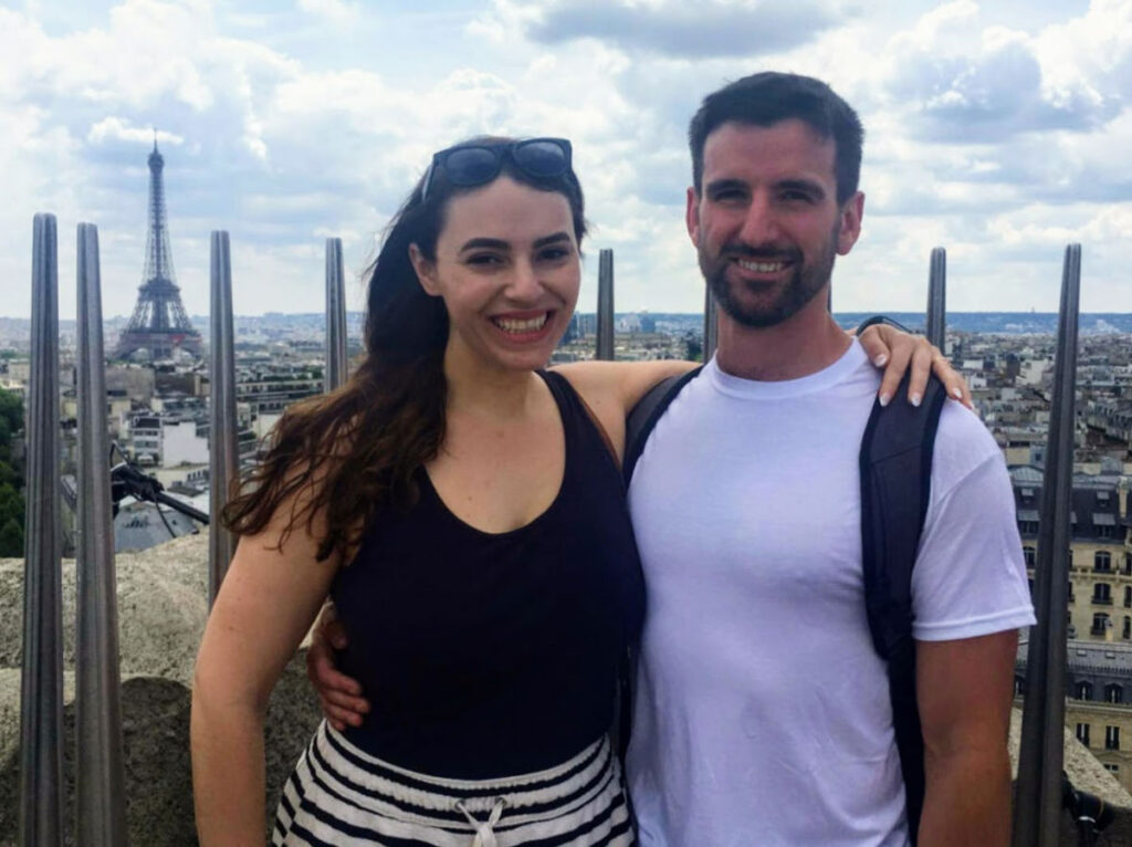 The author's friends Megan and Tim honeymooning with the Eiffel Tower in the background