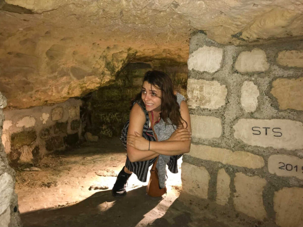The author's friend Megan looking terrified inside the Paris Catacombs