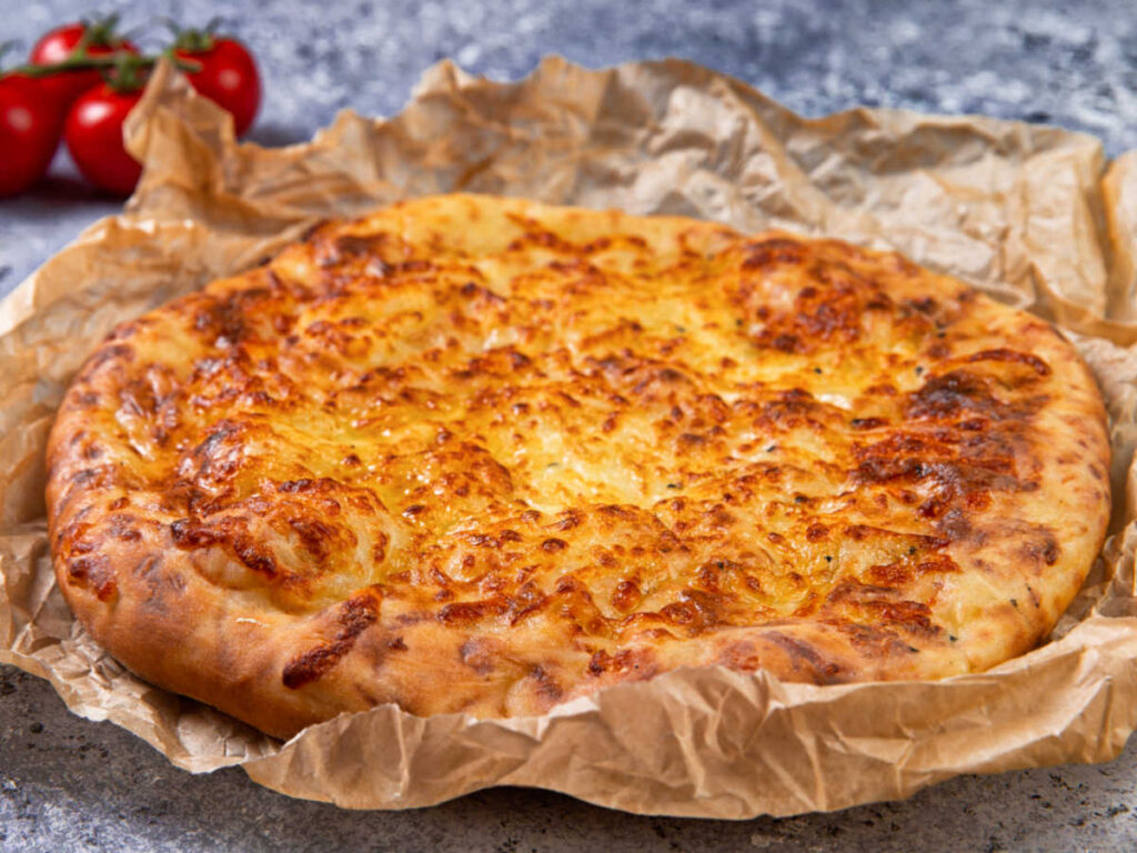 Closeup look of the megruli khachapuri with melted cheese on top