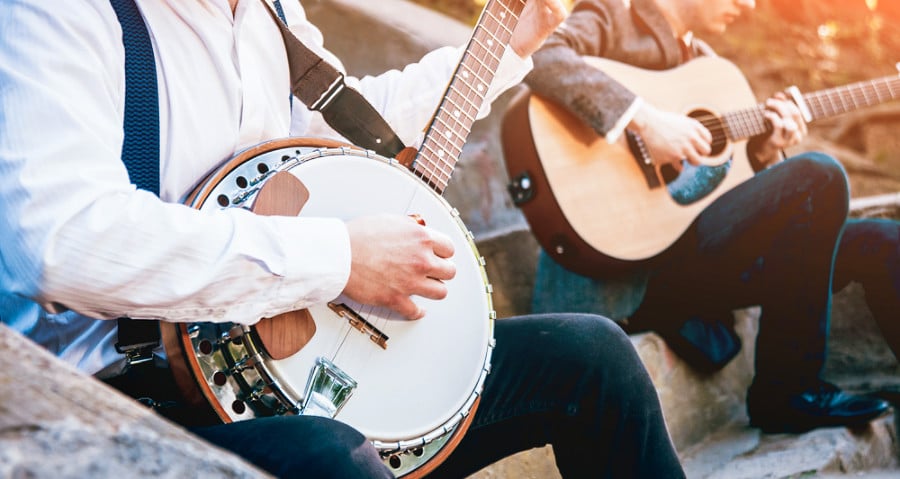 A closeup look at the men playing a banjo and guitar