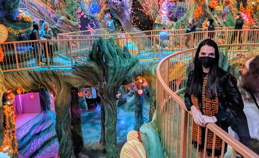 Clara posing for a photo inside the colorful Meow Wolf