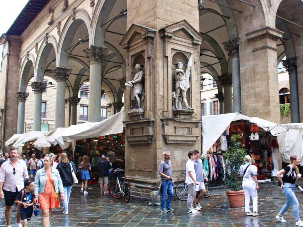 View of the people wandering around Mercato del Porcellino on a rainy day