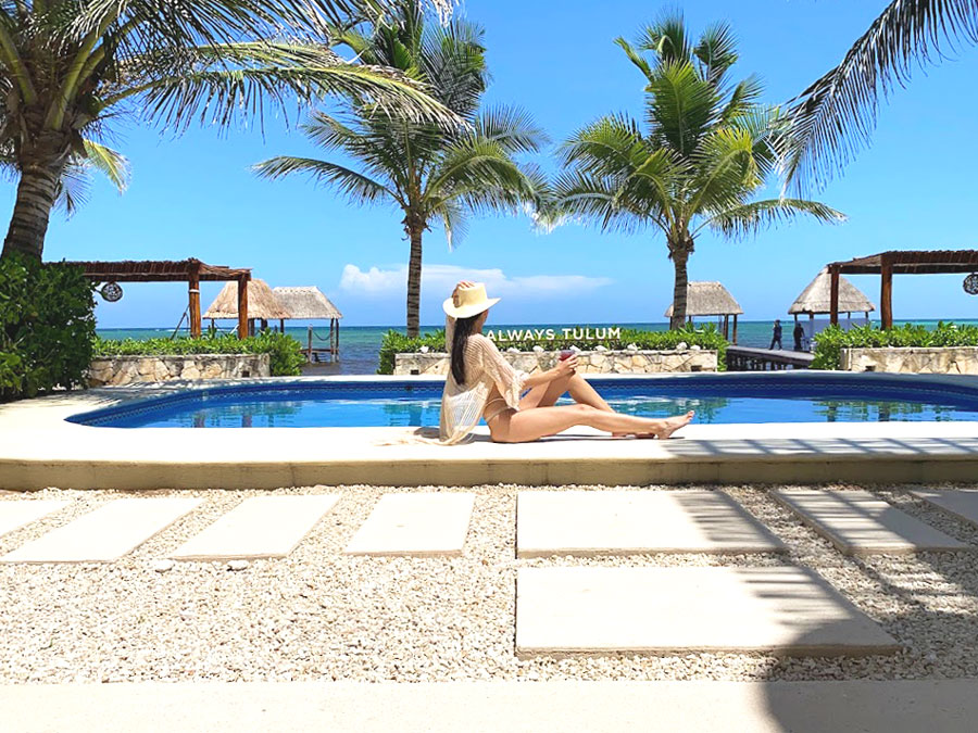 Clara sitting by the pool with view of the ocean
