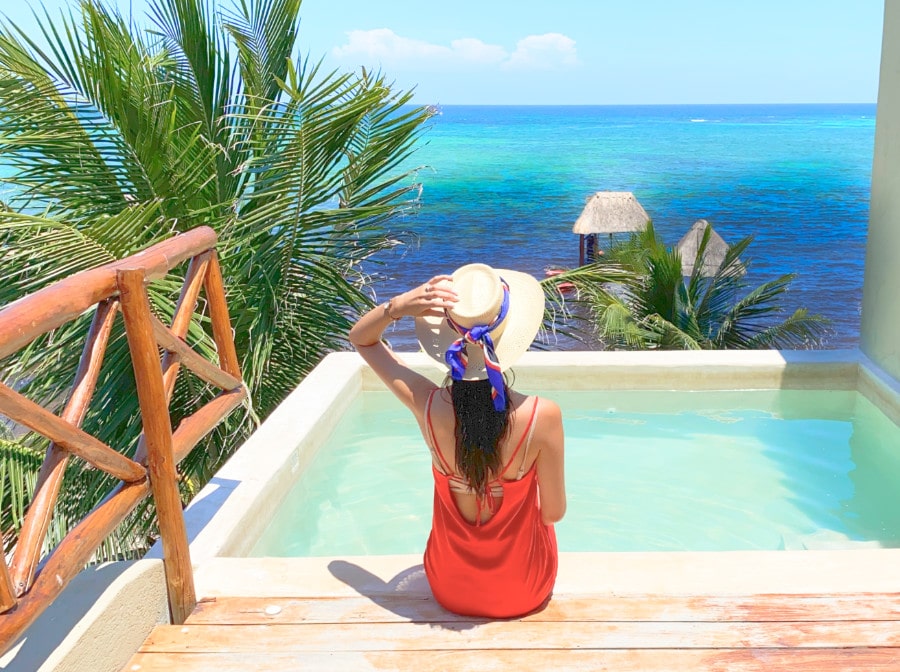 Woman with a hat on a private plunge pool facing the Caribbean sea at Mereva Tulum