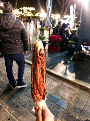A closeup look of a Mexican Elote on a stick