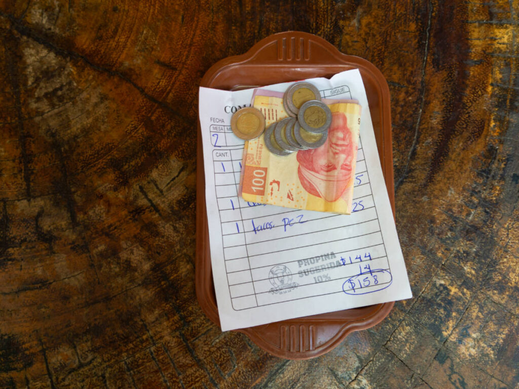Mexican peso bill on a wooden table in a restaurant