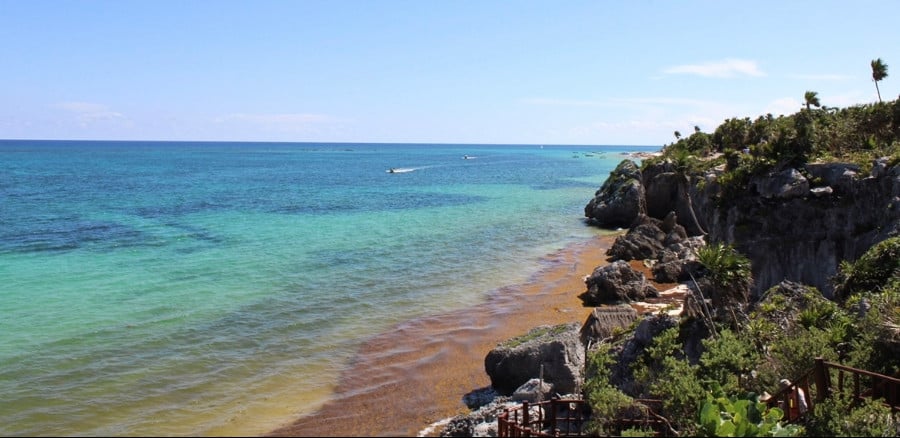 Stunning view of the turquoise beach in the cliff of the mountain with a clear blue sky