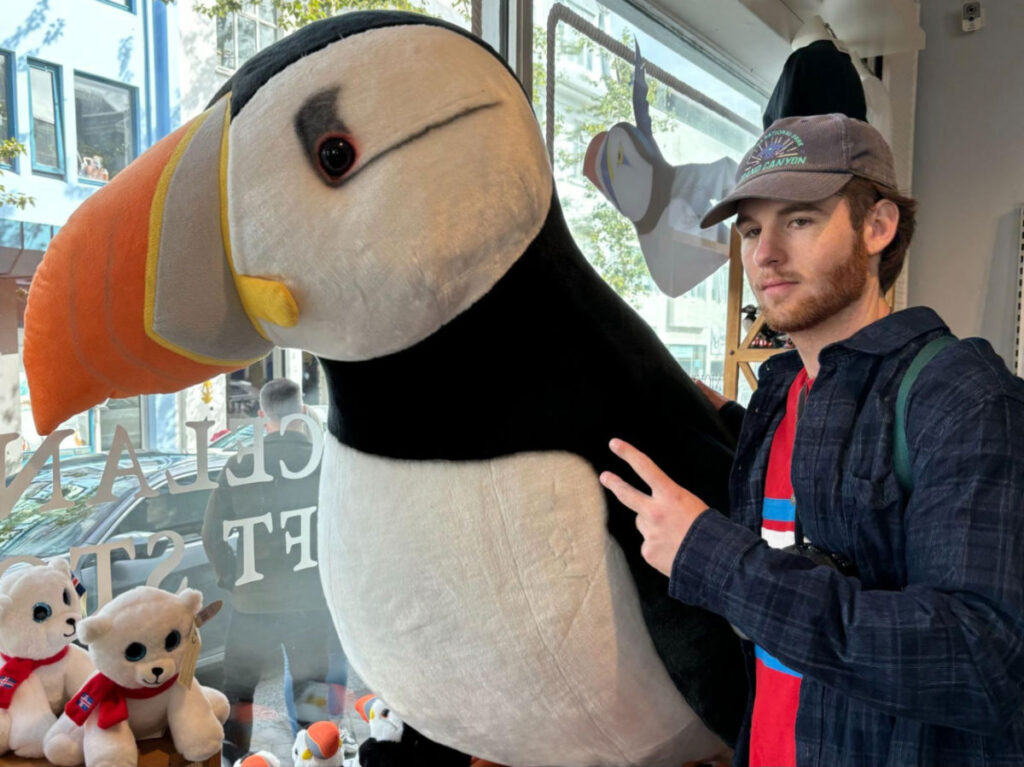 Michael taking a photo with a puffin doll