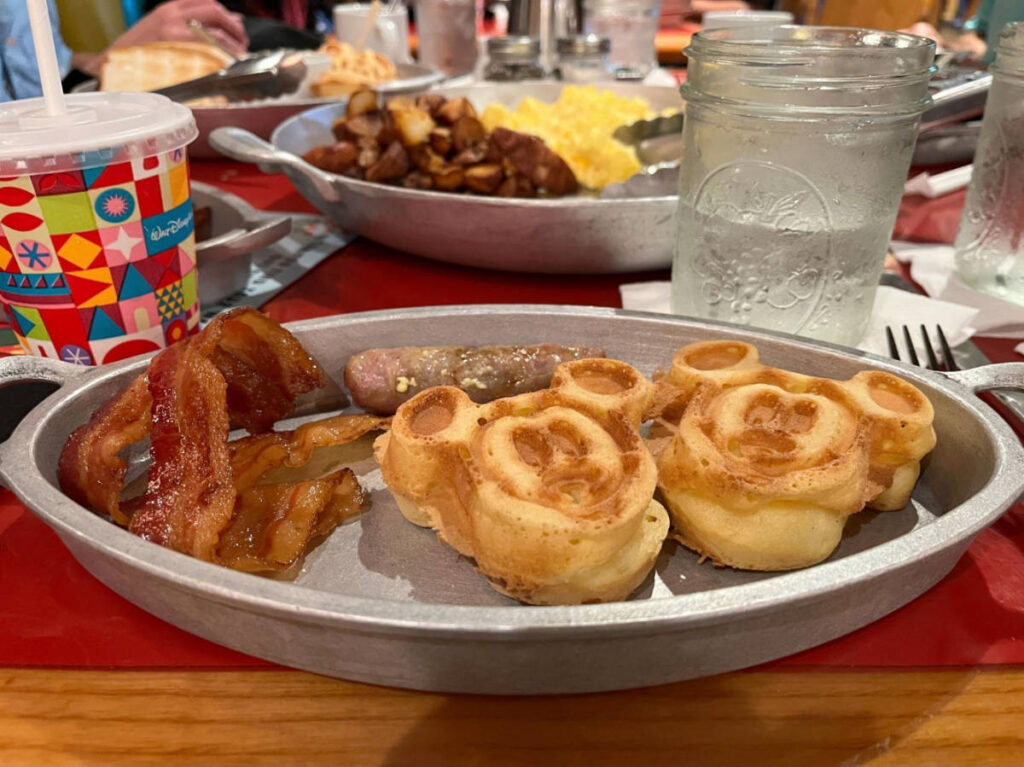 Mickey waffles with bacons and sausage on a plate