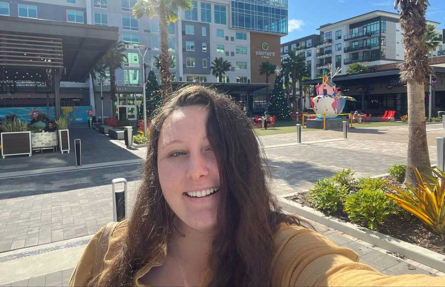 The author Marina Martinelli taking a self-portrait with the shops around Midtown