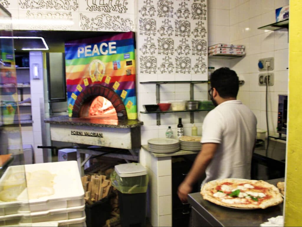 A man preparing a pizza at the Piz pizzeria