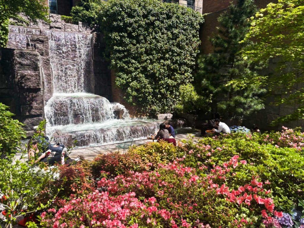 People at the blooming garden with waterfalls view in Greenacre Park