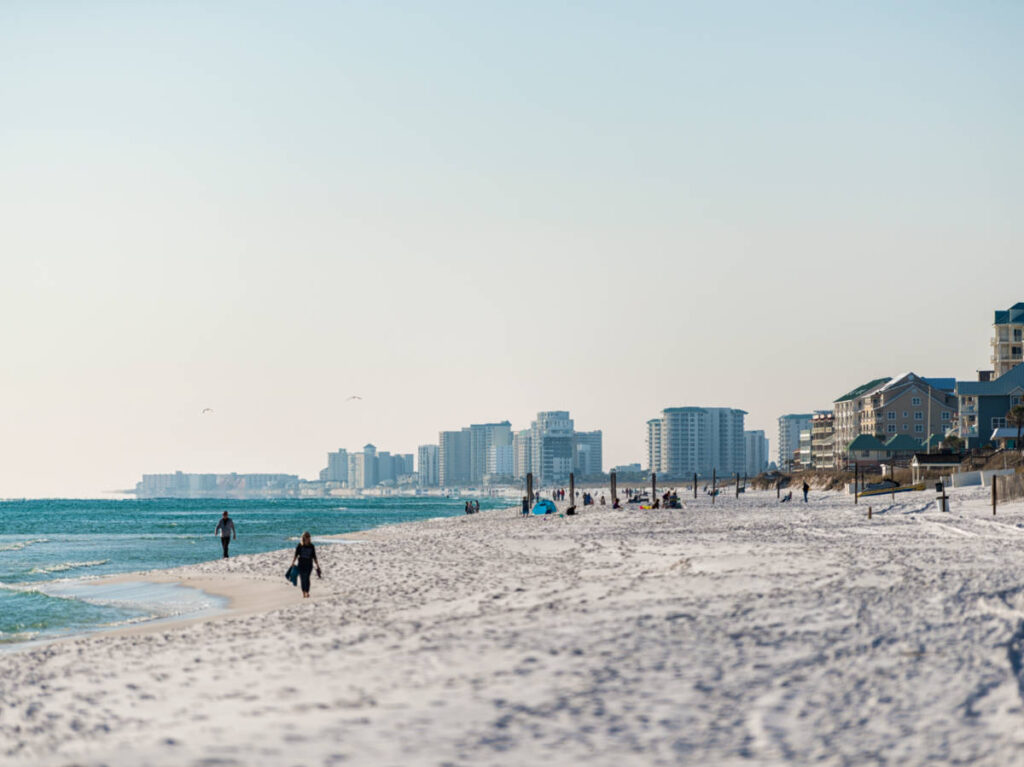 View of the people chilling at the Miramar Beach with a panoramic view of the town in the background