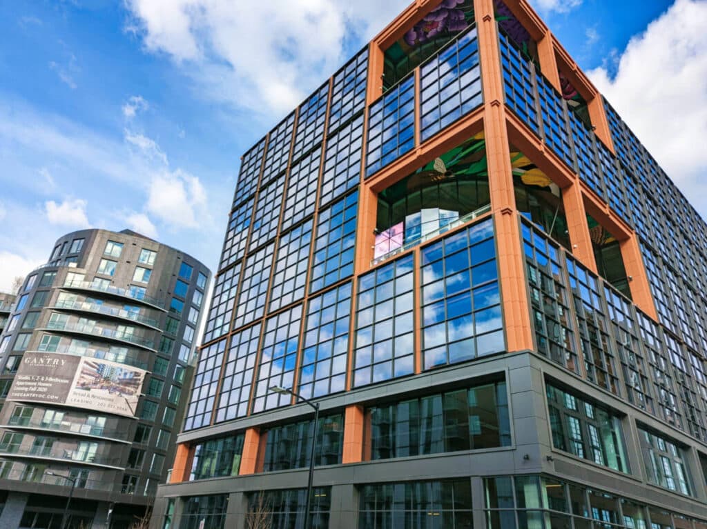 View of the blue sky reflecting in the glass windows of the modern apartment building in NoMa