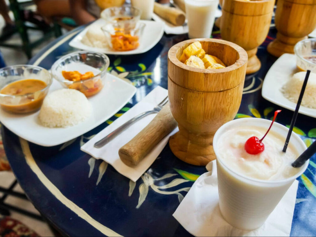 A tbale with meals, drinks and mofongo making at Trianna’s