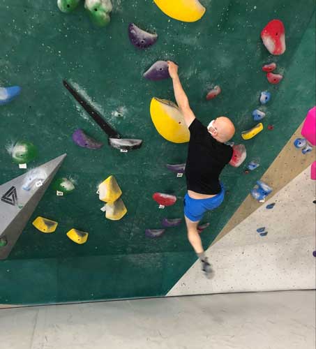 The author's husband doing rock climbing on the Momentum Indoor Climbing