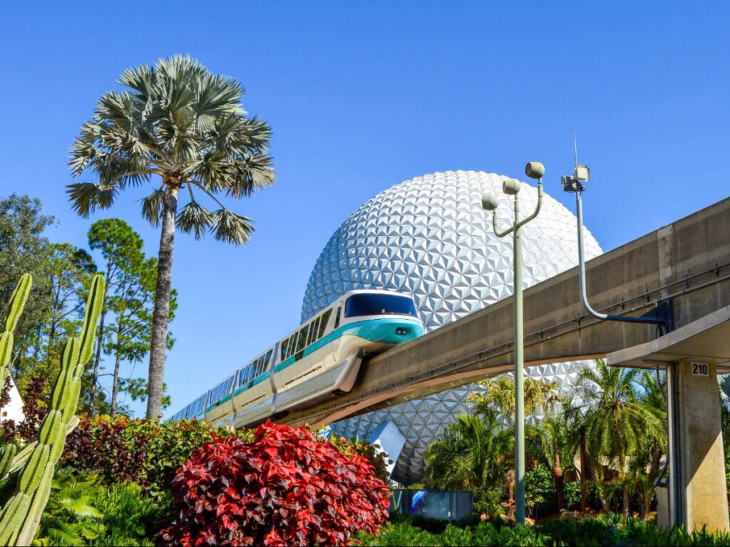 The monorail passing through Epcot under the clear blue sky