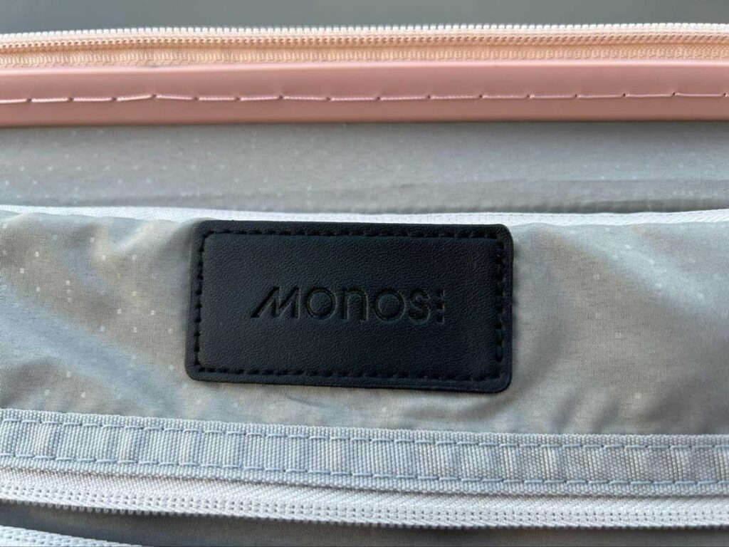 Close up look of the Monos brand tag on the luggage