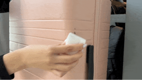 A GIF of Clara cleaning up the Monos luggage with a magic eraser