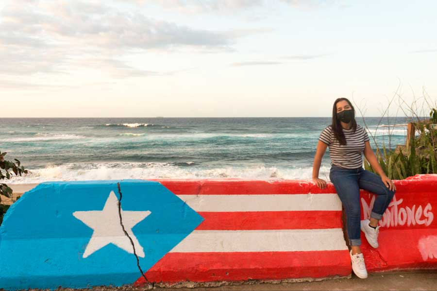 The author sitting on a wall painted with Puerto Rican flag