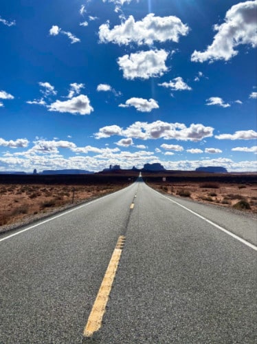 View of the empty highway leading to Monument Valley on a sunny day
