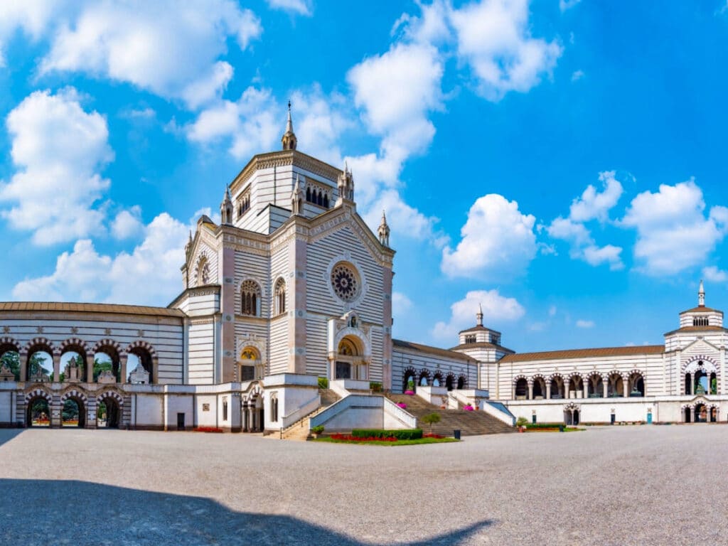 Exterior and entrance view of the Monumental Cemetery with a bright blue sky in the background