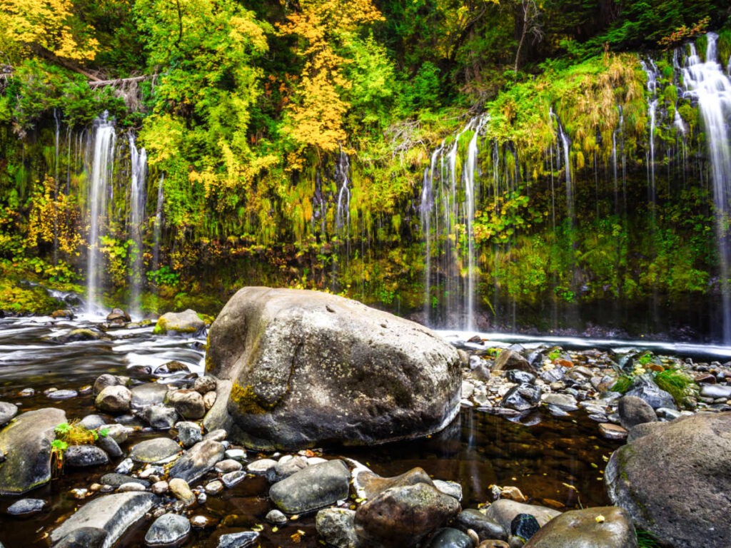 Picturesque view of the multi-waterfall surrounded by greenery and huge rocks at the bottom in Mossbrae Falls