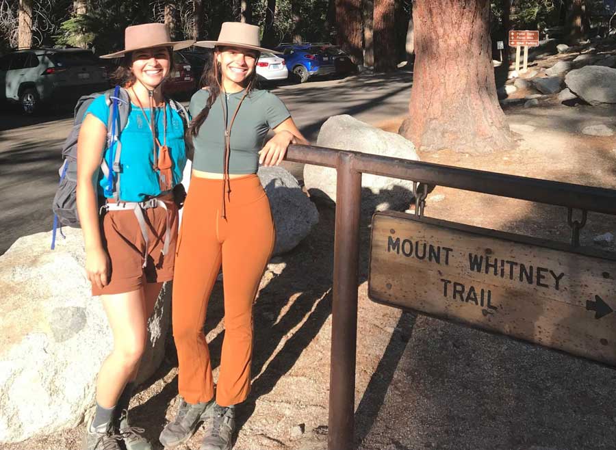 The author with a friend beside a Mount Whitney Trail signage