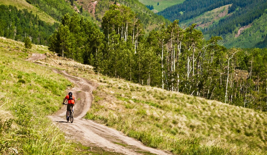A man mountain biking on the trails with scenic view in Crested Butte