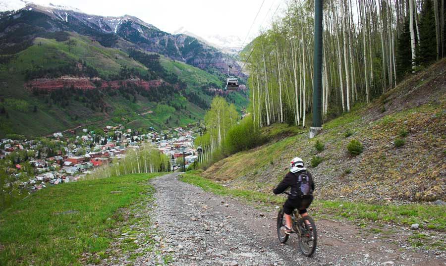 A man mountain biking in Telluride during summer
