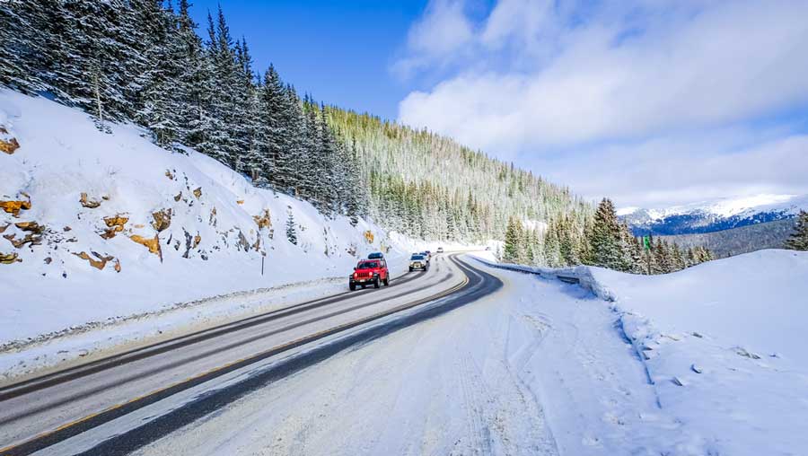 Cars driving along the mountain highway in Colorado during winter season