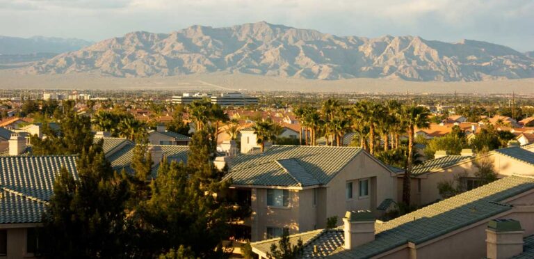 View of a mountain range of the Mojave Desert from afar with houses from one of the neighborhoods