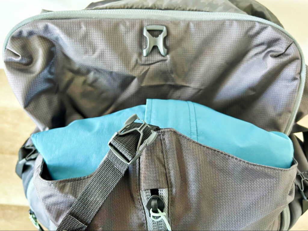 Close up view of the side-release buckle and compression straps of the Mountainsmith Apex backpack