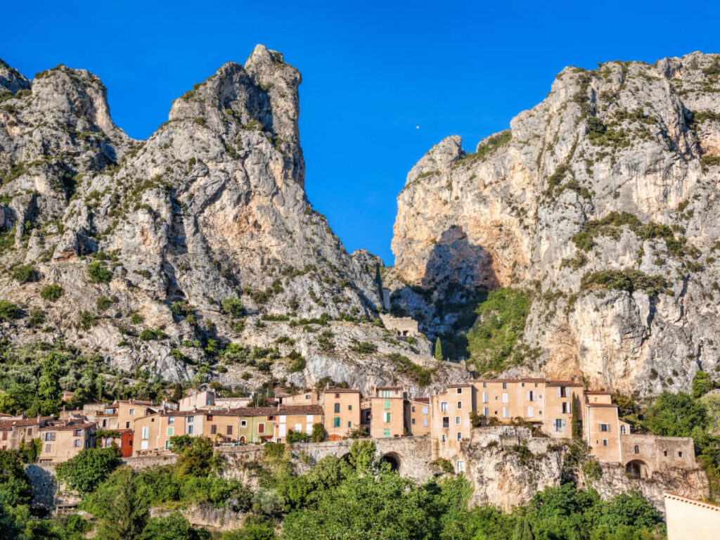 Clear blue sky over the rocky cliffs and houses in Moustiers-Sainte-Marie