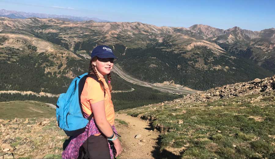 The author's daughter smiling for a photo during a hike in Mt. Sniktau